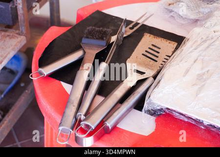 Outil de gril réglé sur fond de gril. Ensemble d'ustensiles de barbecue. Concept de saison barbecue. Griller spatule et autres ustensiles. Préparation de grillades, vue de dessus Banque D'Images