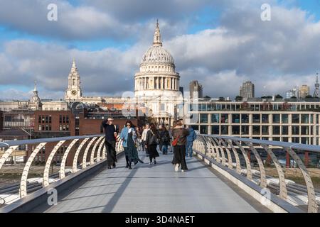Les gens marchent à travers la passerelle London Millennium, également appelée le pont wobbly, Londres, Angleterre, Royaume-Uni, avec la cathédrale Saint-Paul Banque D'Images