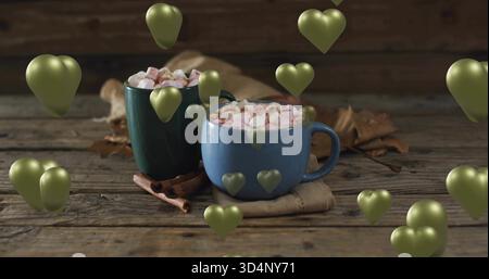 Assis mugs en céramique bleu et vert vapeur dans une cuisine confortable, avec guimauves, cannelle, coeurs Banque D'Images