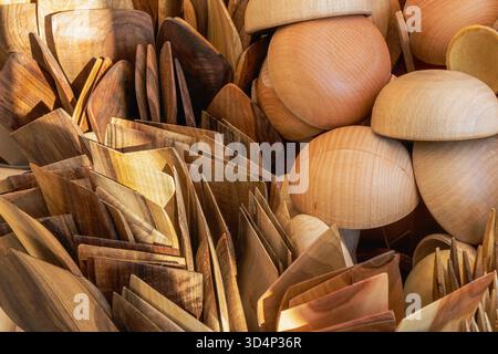 Une vue détaillée des cuillères en bois faites à la main, des spatules et des bols présentés lors d'une foire artisanale. Les textures polies et les tons bois naturels mettent en valeur tradi Banque D'Images