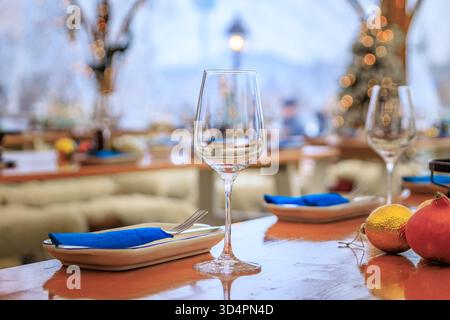 Pays des merveilles hivernales rustiques : tables en bois, jetés de fourrure confortables, arbres de Noël et touches festives attendent les convives dans un restaurant à Zurich, en Suisse Banque D'Images
