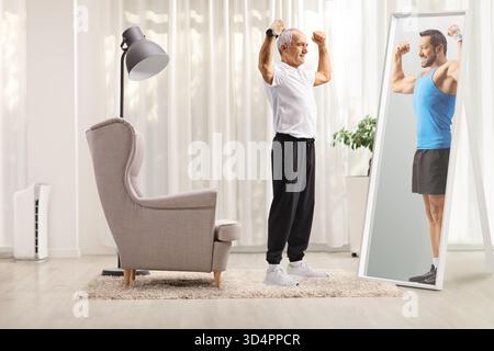 Homme senior en vêtements de sport fléchissant les muscles du bras devant le miroir et regardant sa version plus jeune Banque D'Images
