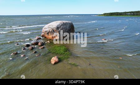 Massif Boulder côtier debout dans les eaux peu profondes de la mer Baltique un jour ensoleillé en Estonie Banque D'Images