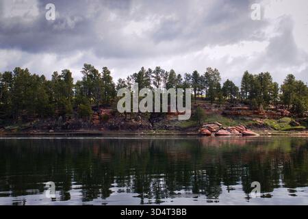 Arbres verts et rochers à côté du lac au parc d'État Keyhole un jour de printemps dans le Wyoming. Banque D'Images