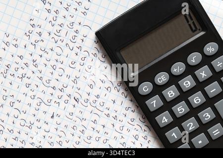 Copybook avec formules mathématiques manuscrites et calculatrice comme arrière-plan, gros plan Banque D'Images