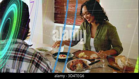Servante femme en chemise verte plaçant le poulet rôti sur l'assiette à la table à manger, avec recouvrement numérique Banque D'Images