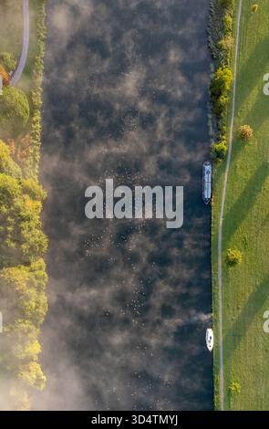 Vue aérienne de brume curling au-dessus des eaux sombres de la Tamise, bordée par des berges verdoyantes et des sentiers, les bateaux amarrés paisiblement, Henley-on- Banque D'Images