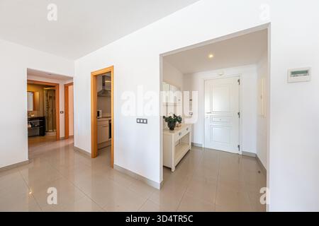 Couloir vide avec murs blancs et sol carrelé dans un appartement immobilier Banque D'Images