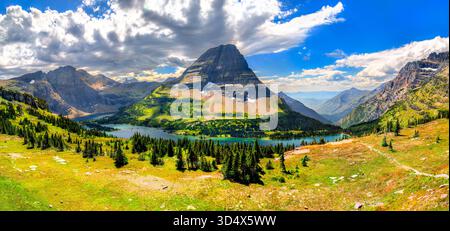Une vue panoramique sur Hidden Lake et Bearhat Mountain depuis le Logan Pass Overlook dans le parc national Glacier, Montana. Une prairie verte est au premier plan sous un ciel nuageux dramatique Banque D'Images