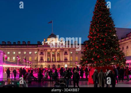 Londres, Royaume-Uni - 1er décembre 2024, Somerset maison cour au crépuscule avec un grand arbre de noël et la patinoire éclairée avec des lumières roses et bleues, surroun Banque D'Images