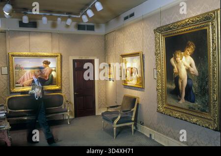 Marchand d'art années 1990 dans sa galerie avec des peintures Belgravia Art Gallery Londres Angleterre. 1999 UK HOMER SYKES Banque D'Images