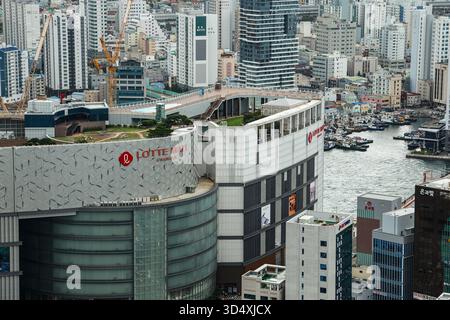 BUSAN, CORÉE DU SUD - 9 OCTOBRE 2025 - paysage urbain de Busan présentant Lotte Mall Gwangbok architecture moderne et dynamique surplombant un port animé Banque D'Images