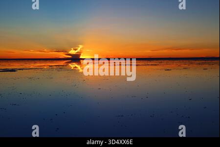 Reflet du ciel du coucher du soleil sur les crues salées, l'effet miroir emblématique à Salar de Uyuni en Bolivie, en Amérique du Sud Banque D'Images