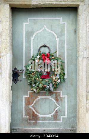 Couronne de noël de l'Avent épicéa naturelle sur la porte en bois vintage. Banque D'Images