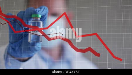 Tenant la main bleutée en nitrile présentant le flacon à bouchon vert dans le laboratoire, travailleur masqué montrant des graphiques rouges Banque D'Images