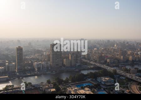 Vue du pont sur la voie navigable tranquille, et les bâtiments avec leurs motifs géométriques sous le ciel brumeux, Zamalek, Gouvernorat du Caire, Egypte. Banque D'Images