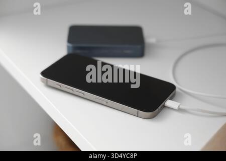 Téléphone portable charge de la banque d'alimentation sur l'étagère dans la chambre, gros plan Banque D'Images