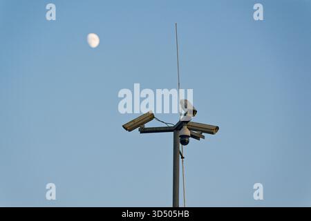 Un poteau de rue haut tient des caméras à bras long pointant dans différentes directions et une unité de dôme ronde qui peut regarder dans tous les angles, le cluster suggère Banque D'Images