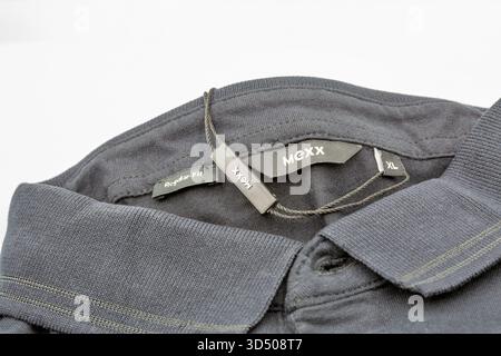 Kiev, Ukraine - 29 mars 2025 : gros plan du polo tricoté noir Mexx affichant plusieurs étiquettes, y compris Regular Fit, étiquette de marque et indicateur de taille XL a Banque D'Images