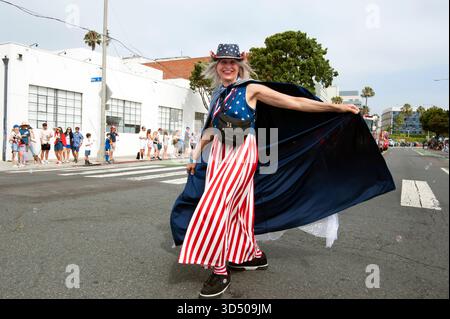 Une femme dans un costume sur le thème du drapeau américain marche lors de la parade annuelle du 4 juillet à Santa Monica, CA, États-Unis Banque D'Images