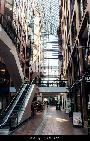 Montréal, Canada - 11 août 2025 : intérieur du World Trade Centre Montréal avec toit en verre moderne, murs de briques et escalator dans le centre d'atri Banque D'Images