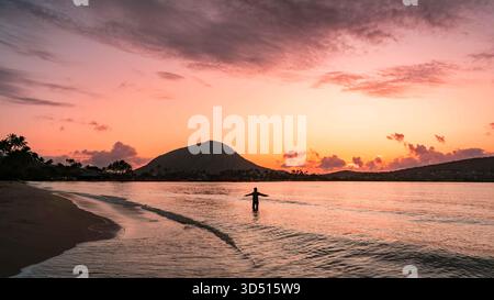 Saluant le lever du soleil sur le cratère Kokohead sur la plage de Kuliouou à Hawaii Kai, Honolulu, Oahu, Hawaii, USA Banque D'Images