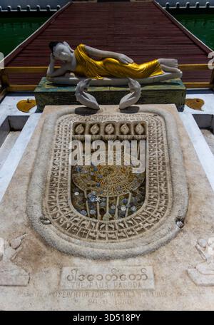 Sculpture ornée d'empreintes de Bouddha en pierre remplie de pièces de monnaie et d'une statue de Bouddha couchée au temple Seema Malaka sur le lac Beira à Colombo, au Sri Lanka. Banque D'Images