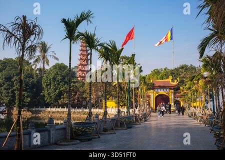 Vietnam : le drapeau national vietnamien et le drapeau bouddhiste flottent au-dessus de la pagode Tran Quoc (temple bouddhiste Tran Quoc), Ho Tay (lac de l'Ouest), Hanoi. Le plus ancien temple de Hanoi, Chua Tran Quoc, se trouve sur une petite île juste à l’ouest de la chaussée à Ho Tay (lac de l’Ouest). Les origines précises de la pagode sont inconnues, mais selon la légende, elle a été établie à l’origine par les rives de la rivière Rouge sous le règne du roi Ly Nam de (544-48) lors d’un bref interrègne au cours du millénaire de l’occupation chinoise. Il a été déplacé sur l'île Kim Ngu au cours du XVIIe siècle. Banque D'Images