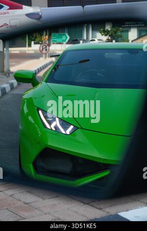 Dubaï, Émirats arabes Unis - 13 juillet 2024 : une vue rapprochée de la section avant et des phares distinctifs d'une voiture de sport Lamborghini Huracán vert néon reflétait i. Banque D'Images