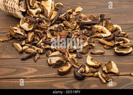 Assortiment rustique de tranches de champignons porcini séchés étalées sur une table en bois Banque D'Images