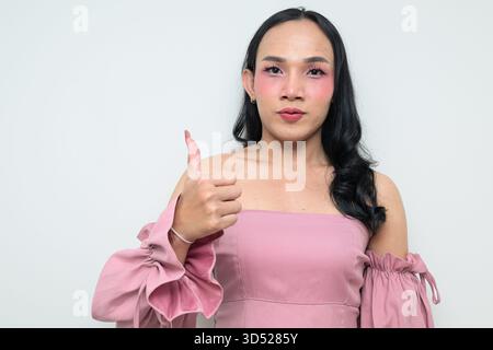 Portrait studio d'un jeune transgenre thaïlandais avec maquillage et cheveux longs. Concept d'expression de genre, fierté LGBTQ et inclusivité montrant un Banque D'Images