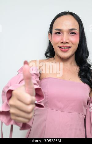 Portrait studio d'un jeune transgenre thaïlandais avec maquillage et cheveux longs. Concept d'expression de genre, fierté LGBTQ et inclusivité montrant un Banque D'Images