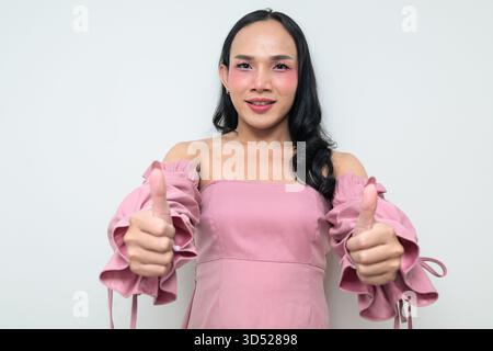 Portrait studio d'un jeune transgenre thaïlandais avec maquillage et cheveux longs. Concept d'expression de genre, fierté LGBTQ et inclusivité montrant un Banque D'Images