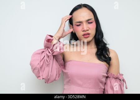 Portrait studio d'un jeune transgenre thaïlandais avec maquillage et cheveux longs. Concept d'expression de genre, fierté LGBTQ et inclusivité montrant un Banque D'Images
