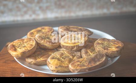 Quartiers de pommes de terre dorés au four avec des épices sur une plaque en céramique, vue de haut en bas pour la photographie de nourriture rustique Banque D'Images