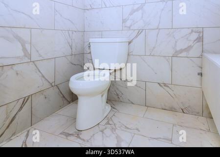 Salle de bains propre avec toilettes blanches élégantes carreaux de marbre dans un design spacieux. Banque D'Images