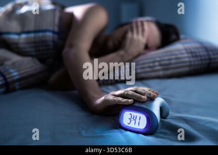 Insomnie et trouble des apnées du sommeil. Femme la nuit avec alarme. Mauvaise anxiété avec horloge. Cauchemar trouble au lit. Personne déprimée sans sommeil. Banque D'Images