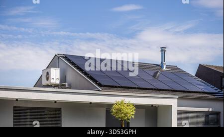 Toit de maison moderne avec système de division d'onduleur et panneaux solaires installés Banque D'Images