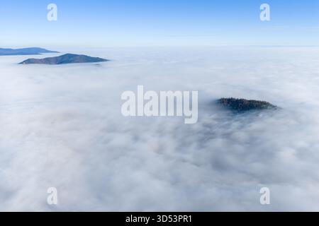 Vue aérienne des îles perçant une mer de nuages moelleux sous un ciel clair, une danse envoûtante de terre et de ciel, Orschwiller, Grand est, France Banque D'Images