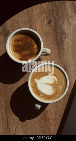 Vue aérienne d'un cappuccino et d'un café latte côte à côte sur une table en bois Banque D'Images