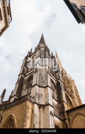 Une vue vers le haut capture l'architecture complexe d'une cathédrale gothique de Bayonne, en France, avec le ciel comme toile de fond. Banque D'Images