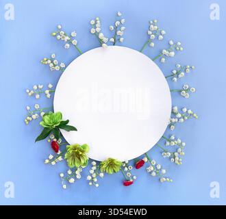 Fleurs blanches Lily of the Valley ( Convallaria ), fleurs blanches vertes hellebores, marguerites roses et cercle carte blanche avec espace Banque D'Images