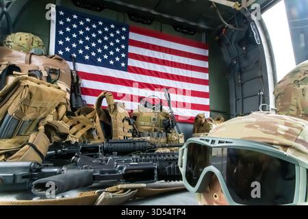 ChatGPT a dit : équipement militaire est affiché à l'intérieur d'un hélicoptère UH-60 Blackhawk avec un drapeau américain en arrière-plan, symbolisant la force, la disponibilité, Banque D'Images