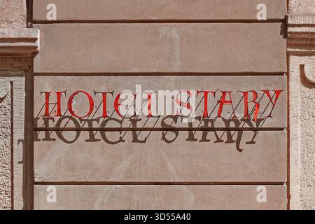 Le lettrage ensoleillé « Hotel Stary » projette une ombre nette sur un mur texturé du bâtiment. Banque D'Images