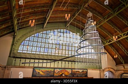 Bâle, Suisse - 16 novembre 2024 : magnifique luminaire en forme de sapin de Noël suspendu au plafond en bois de la gare historique de CFF Banque D'Images