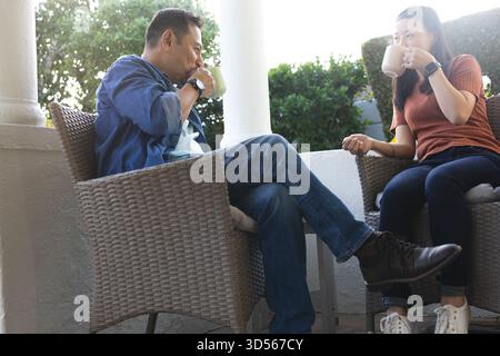 Couple mature appréciant le café ensemble sur le patio, partageant une conversation détendue Banque D'Images