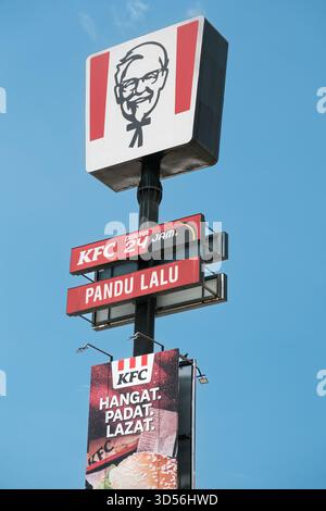 Penang, Malaisie - 16 octobre 2025 : une enseigne de restaurant KFC affiche le logo emblématique et la bannière promotionnelle sur fond bluesy Banque D'Images