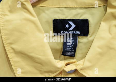 Penang, Malaisie - 16 octobre 2025 : une veste Converse jaune avec un logo bien visible affiche des détails de marque. Banque D'Images