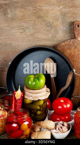 Légumes conservés dans des bocaux en verre sur un fond en bois. Le concept de conserves alimentaires. Banque D'Images