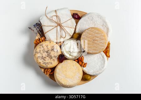Présentation artistique de fromages assortis et d'en-cas sur un plateau en bois pour une réunion décontractée Banque D'Images